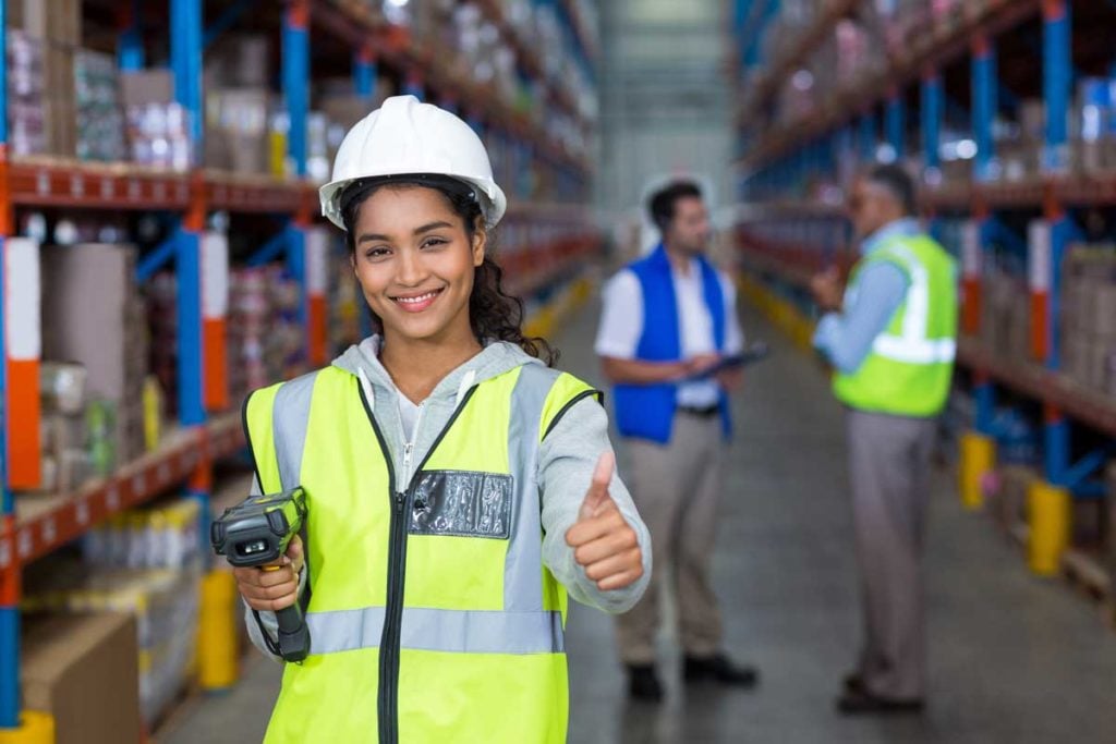 Female warehouse worker showing thumbs up sign